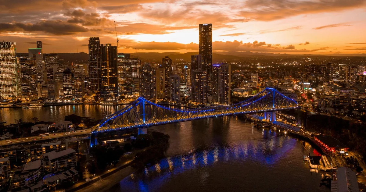 Brisbane city CBD skyline and illuminated Story Bridge at sunset over the Brisbane River